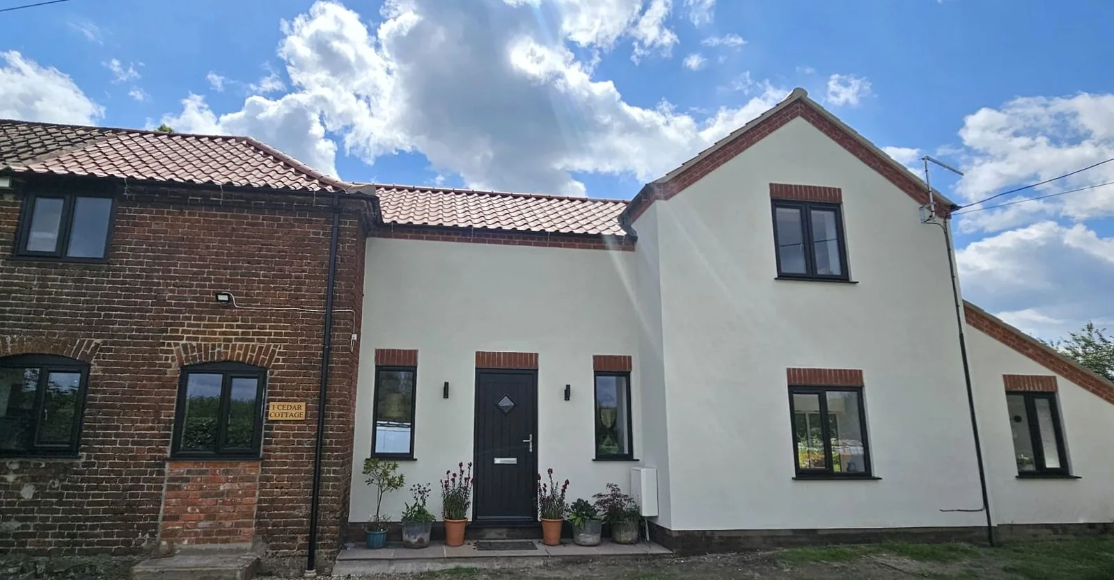 Two storey home with white exterior finish and brick details