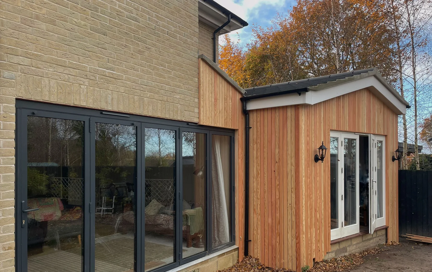 Timber clad rear extension with dark framed glazing and garden doors